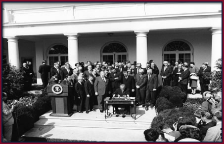President Lyndon B. Johnson signs the Economic Opportunity Act of 1964 at the White House, launching the national Community Action movement