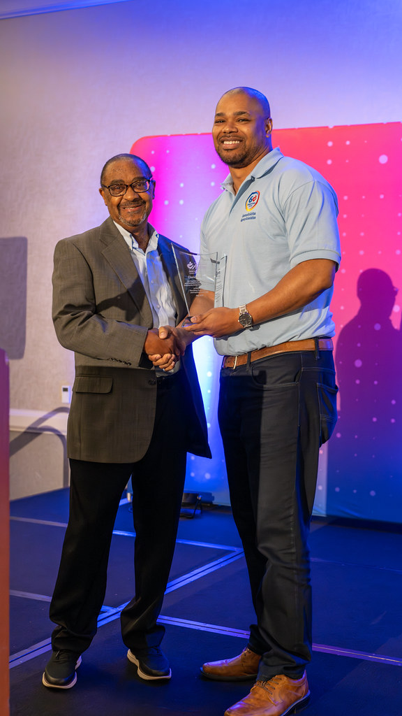 An award recipient shaking hands with the presenter on stage