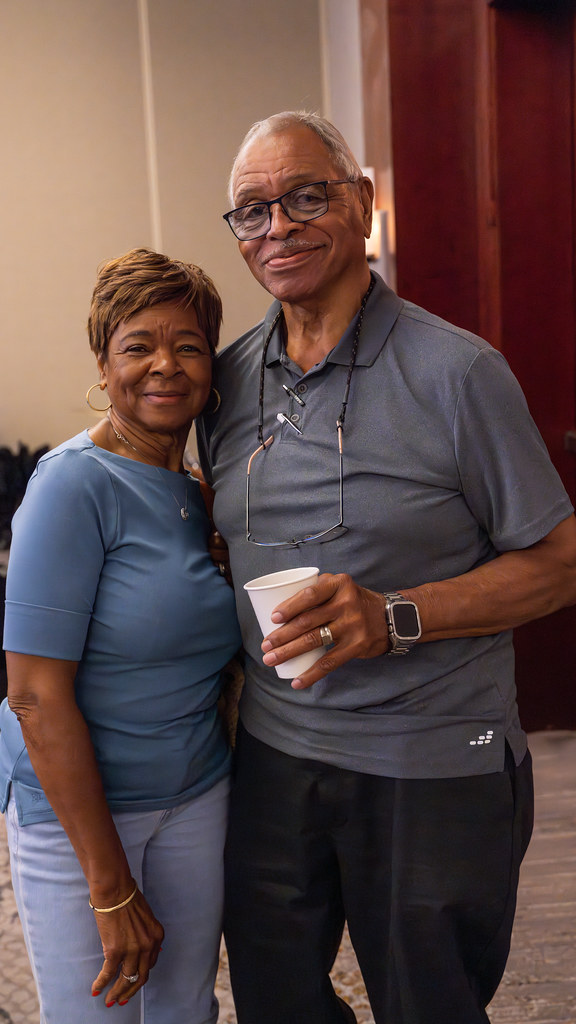 Two smiling attendees posing together during a conference break